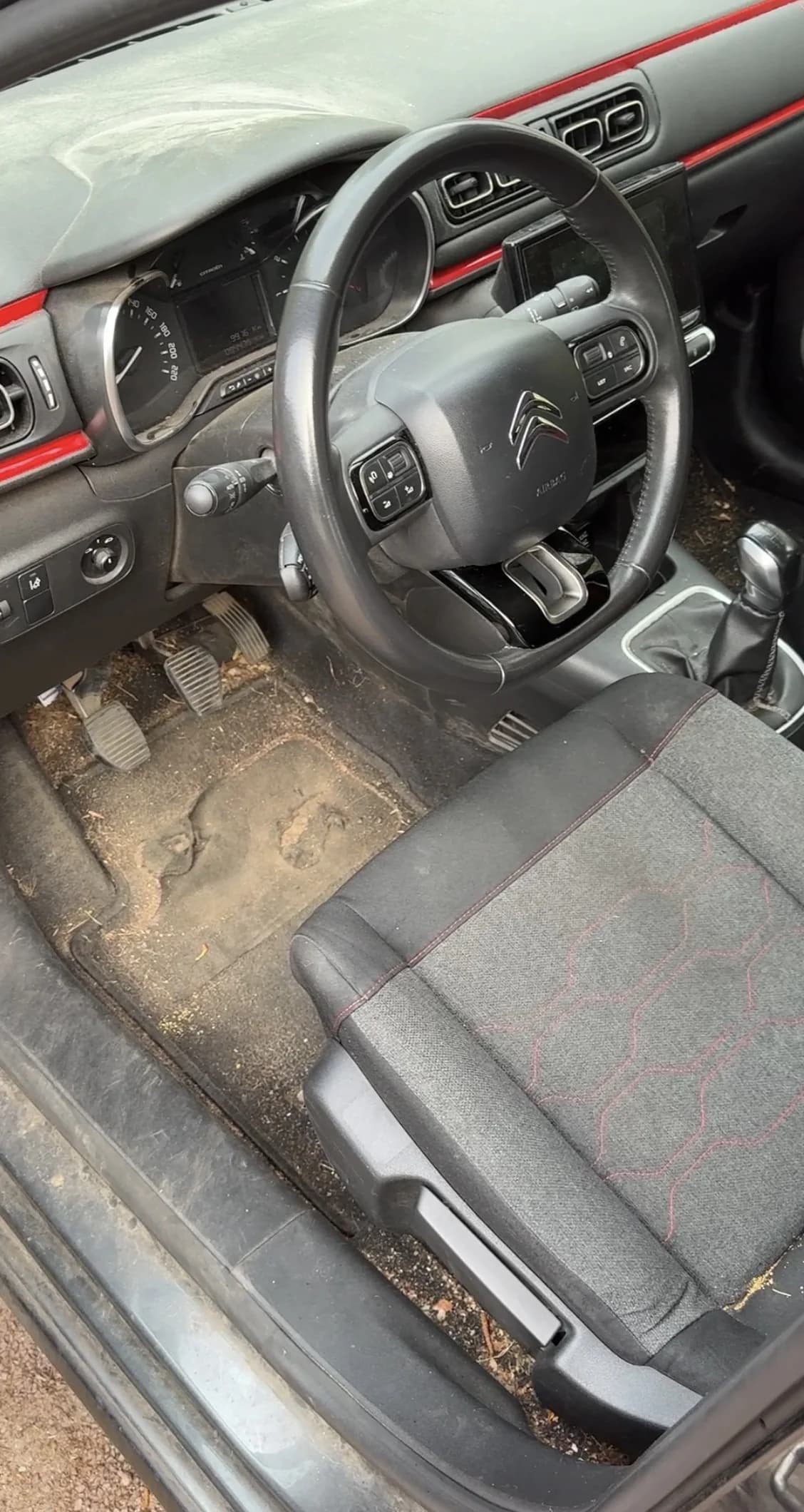 Habitacle et plancher d'une Citroën C3 couverts de terre et de débris — avant nettoyage
